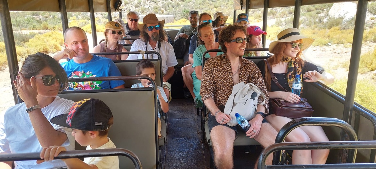 Big Five safari from Cape Town — guests on an open 4x4 game drive through Karoo bushveld at Aquila Private Game Reserve